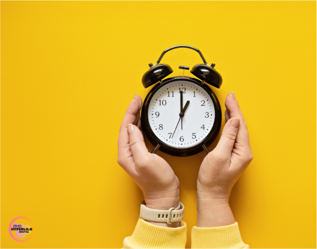 Image Alt text: Hands hold a black alarm clock on a yellow background.